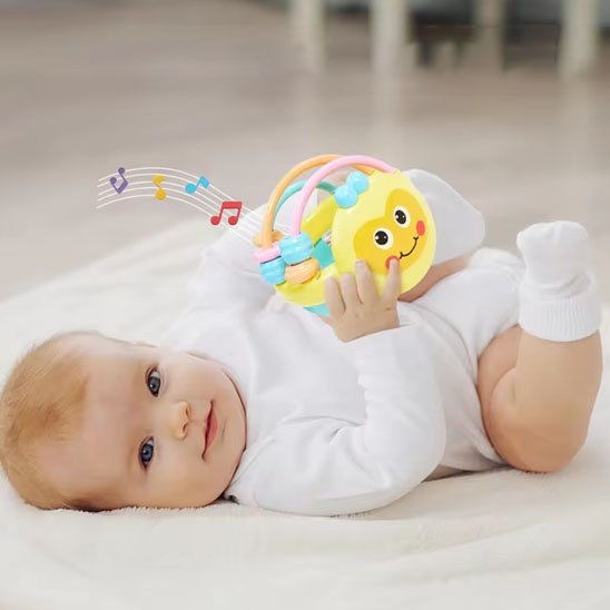 Bébé souriant joue avec son Hochet sensoriel