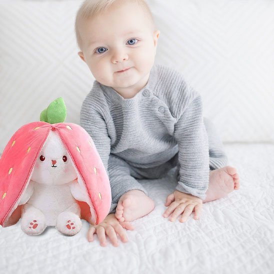 Bébé avec peluche lapin fraise