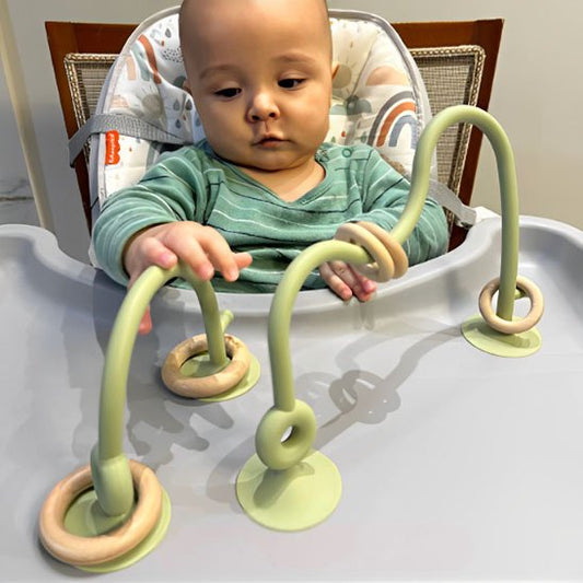 bébé jouant avec anneau de dentition coloré