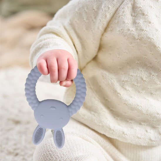 bébé jouant avec anneau de dentition lapin
