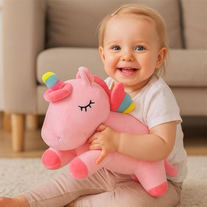 bébé souriant avec licorne peluche