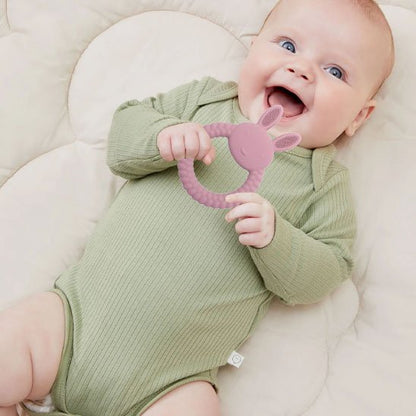 bébé souriant regardant anneau de dentition silicone